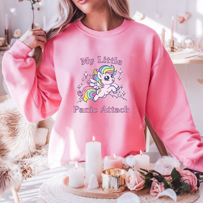 Person wearing a pink sweatshirt with a unicorn graphic and text in a cozy indoor setting.